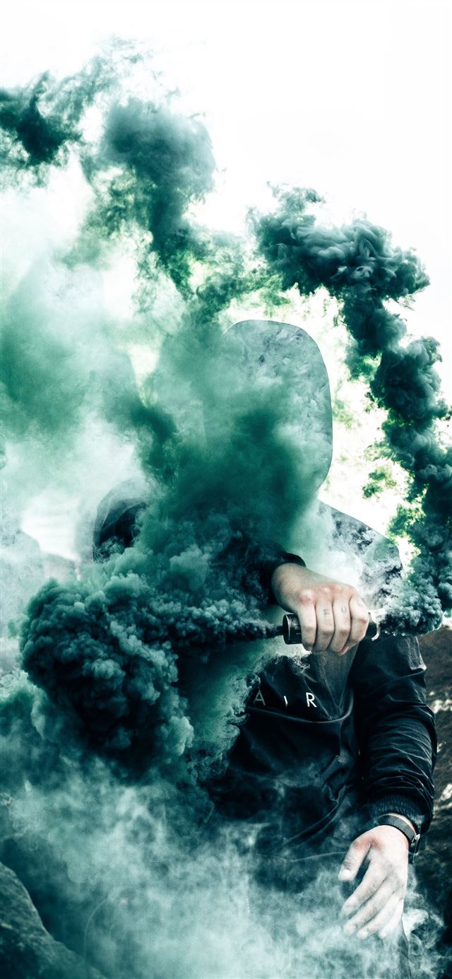 1125x2436 person holding gas grenade - canada iPhone 11 Wallpaper