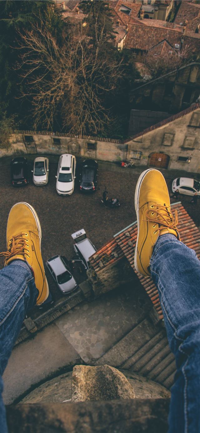 1125x2436 person sitting on rooftop - city iPhone 11 Wallpaper
