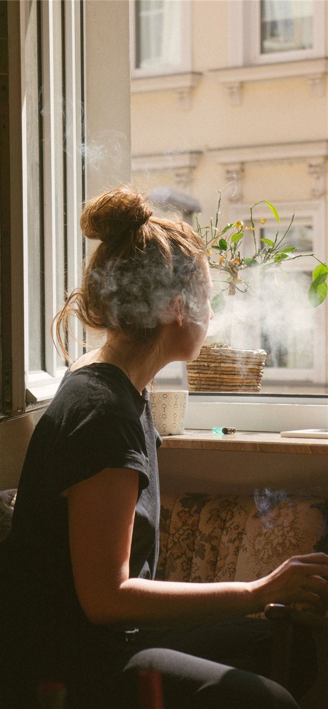 1125x2436 woman smoking while look through the window - germany iPhone 11 Wallpaper