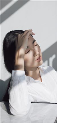 woman leaning on white table iPhone 11 wallpaper