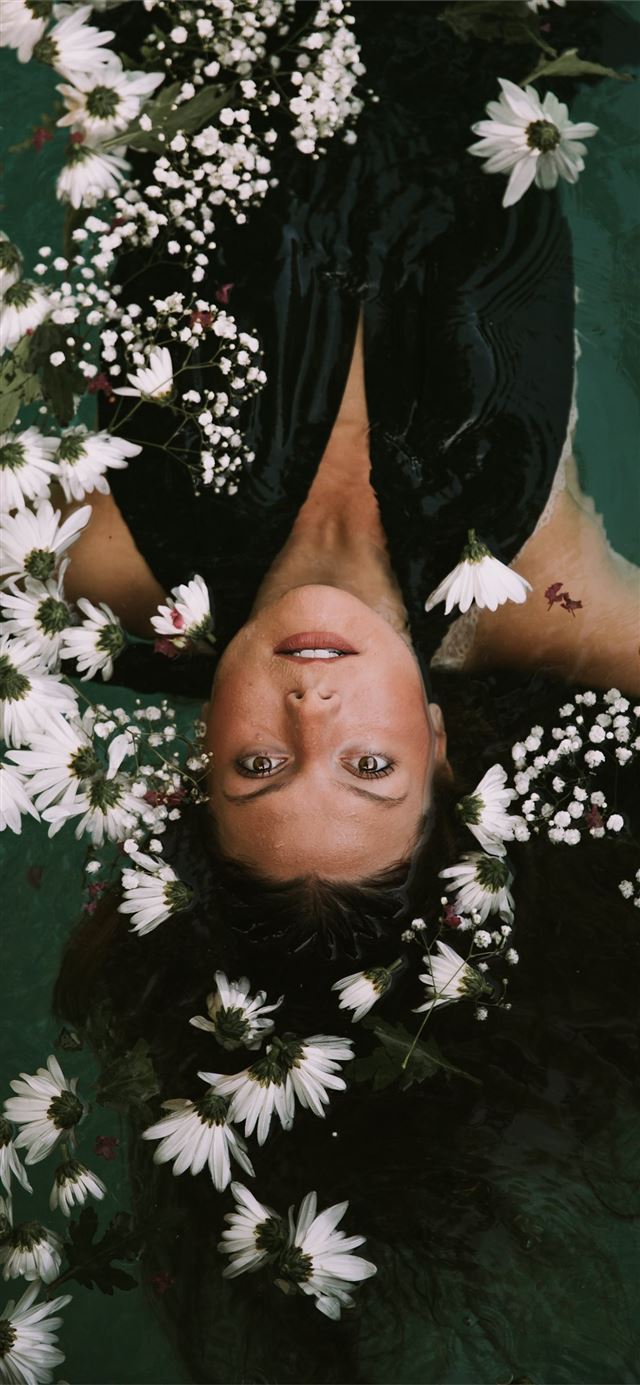 1125x2436 woman swimming covered by white daisies - beauty iPhone 11 Wallpaper