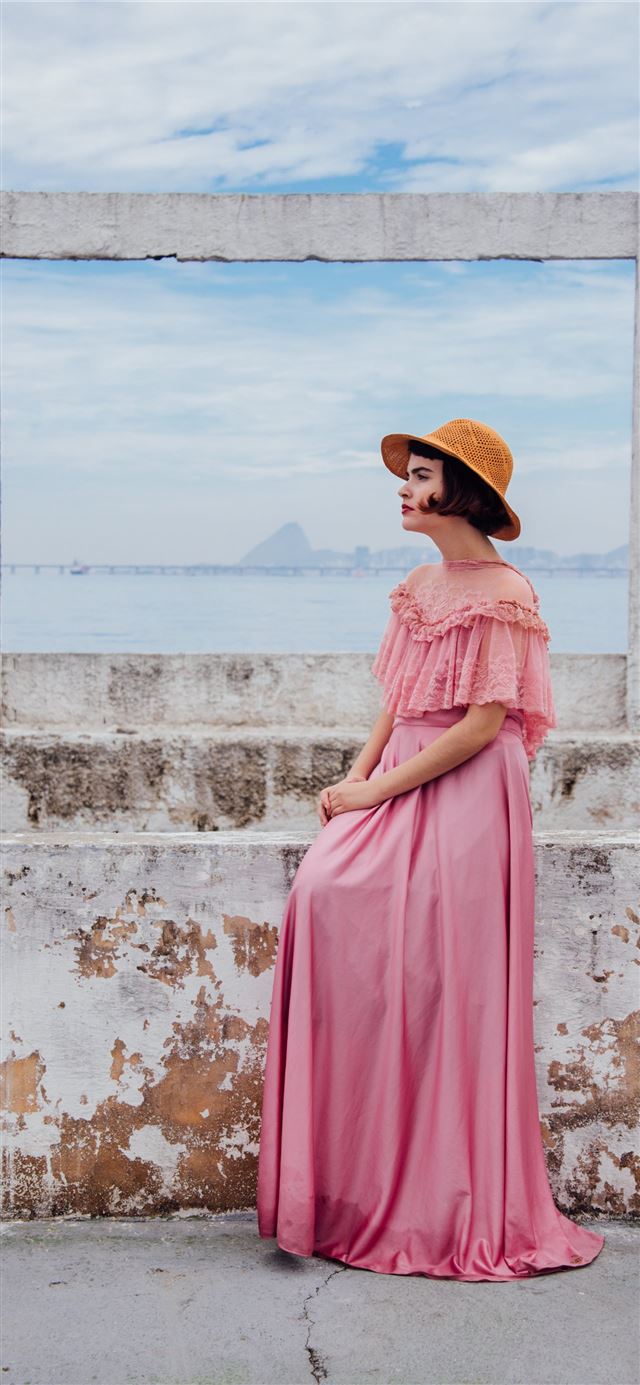 1125x2436 woman wearing pink dress standing next to white wa... - rio de janeiro iPhone 11 Wallpaper