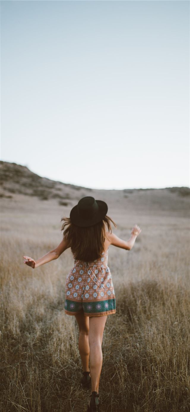 1125x2436 woman wearing brown and green floral romper walkin... - girls iPhone 11 Wallpaper