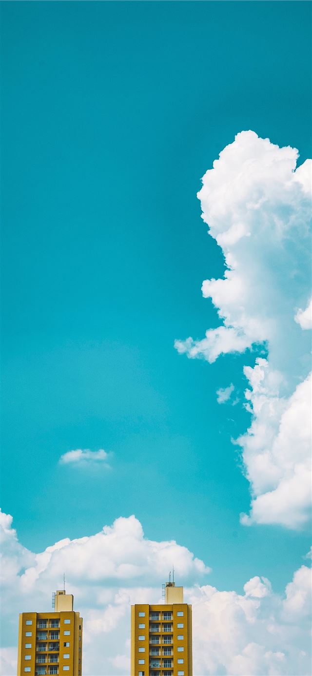 1125x2436 two brown tall buildings under white sky during da... - sky iPhone 11 Wallpaper