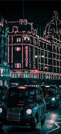 black taxi in the street passing trough Harrods Ma... wallpaper