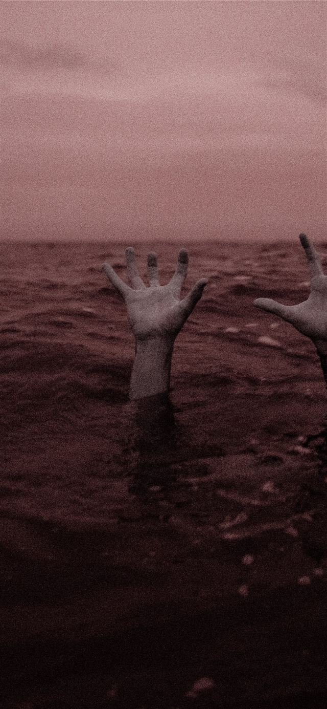 1125x2436 person sinking on body of water - dark (black) iPhone 11 Wallpaper