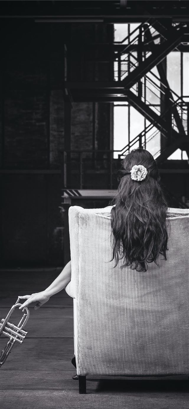 1125x2436 woman sitting on chair holding trumpet - music iPhone 11 Wallpaper