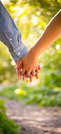 shallow focus photo of man and woman holding hands iPhone 11 wallpaper