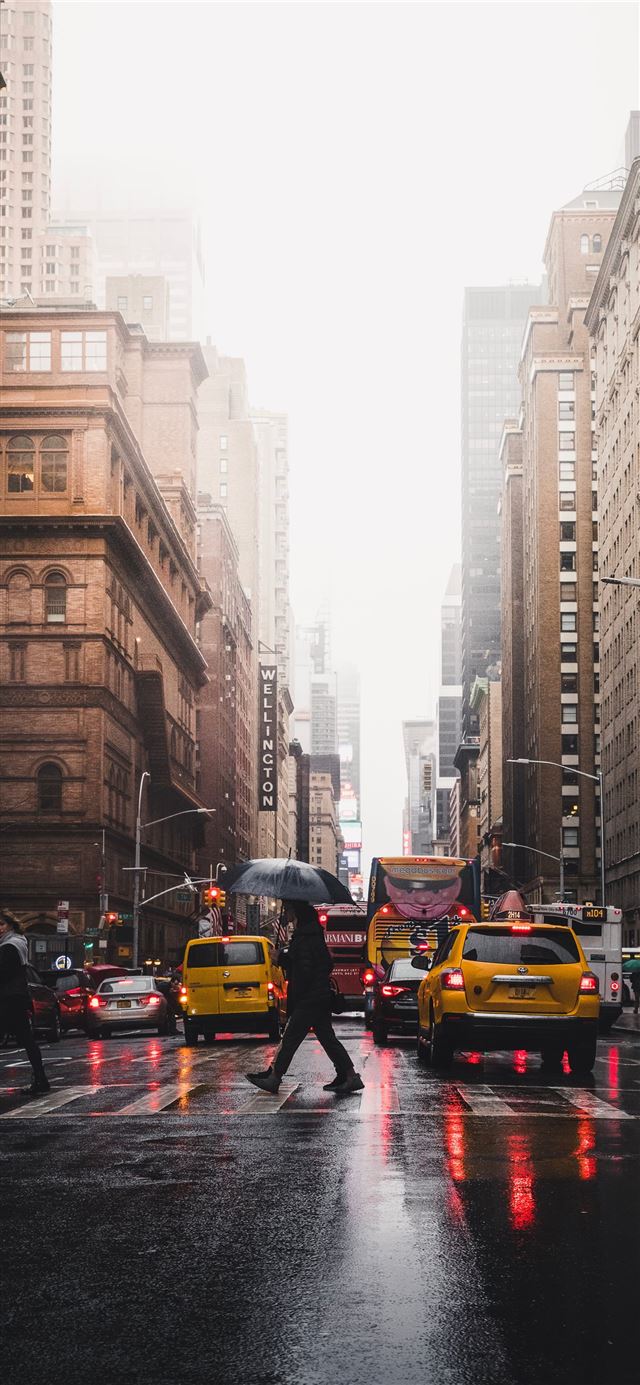 1125x2436 person walking on pedestrian lane between building... - yellow iPhone 11 Wallpaper