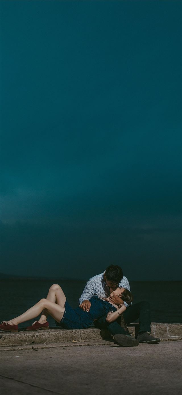 1125x2436 man kissing woman while sitting on railings during... -  iPhone 11 Wallpaper