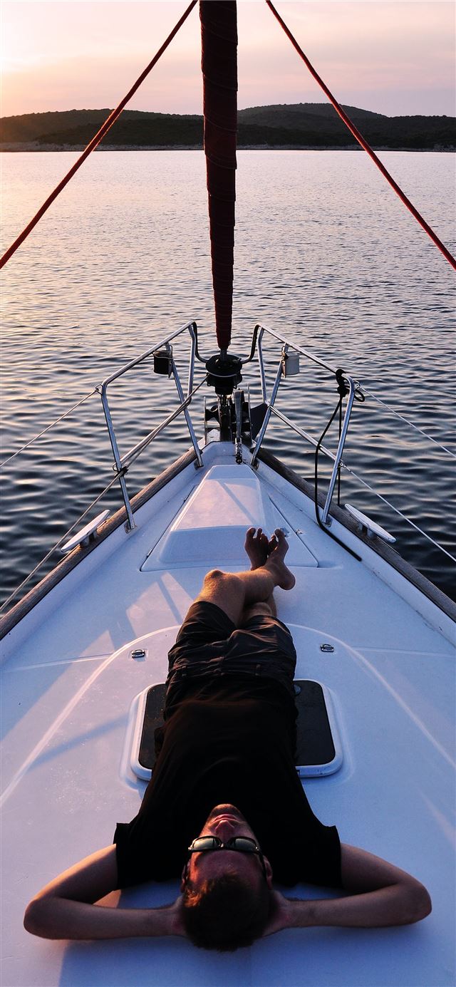 1125x2436 man lying on white boat -  iPhone 11 Wallpaper