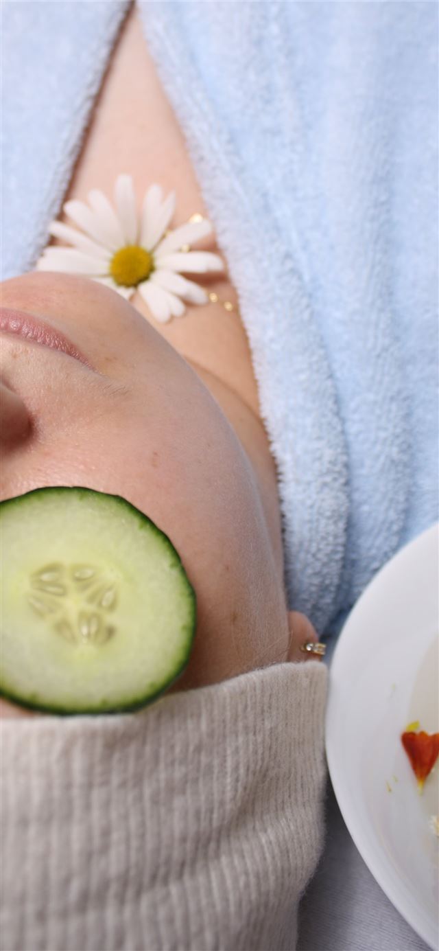 1125x2436 woman wearing blue robe lying with cucumber on eye -  iPhone 11 Wallpaper