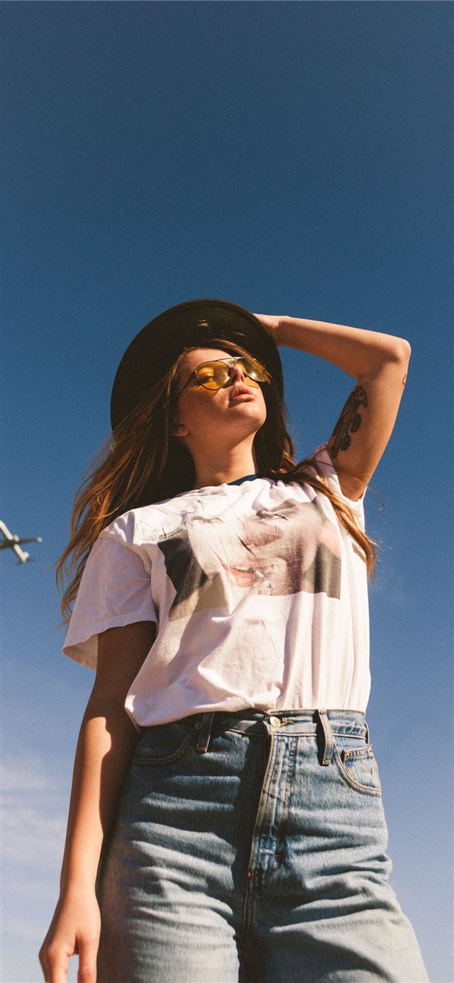 1125x2436 woman holding her black hat -  iPhone 11 Wallpaper