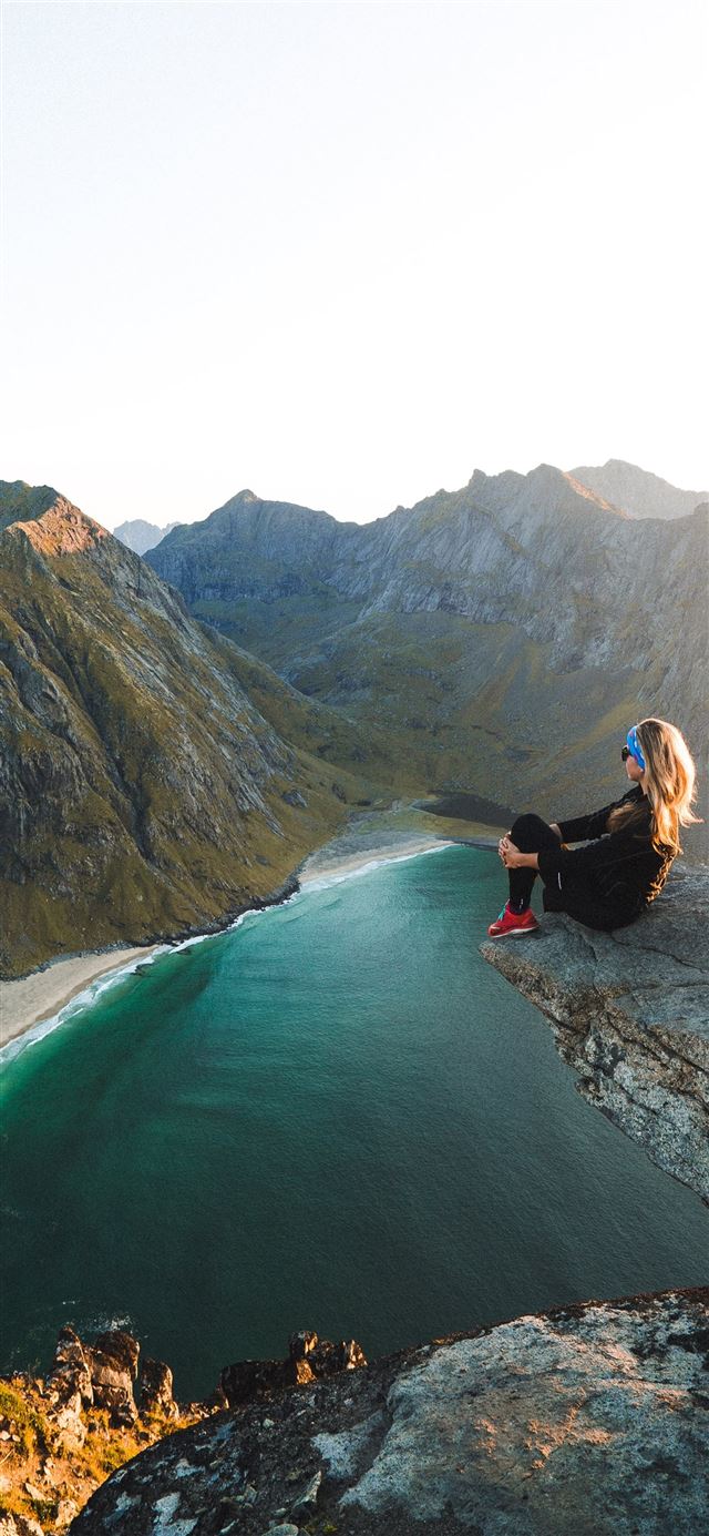1125x2436 woman sitting on cliff overlooking body of water n... -  iPhone 11 Wallpaper