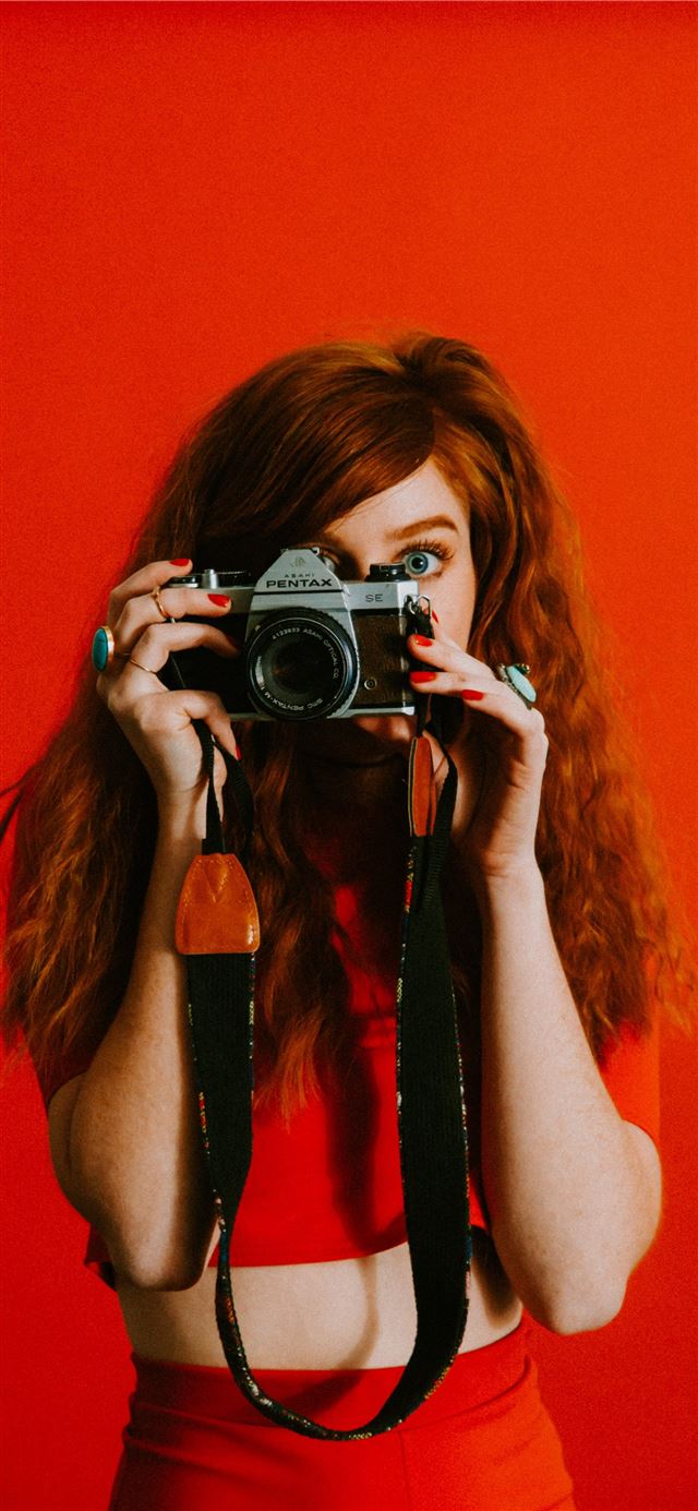 1125x2436 woman in red top and bottoms holding Pentax camera -  iPhone 11 Wallpaper
