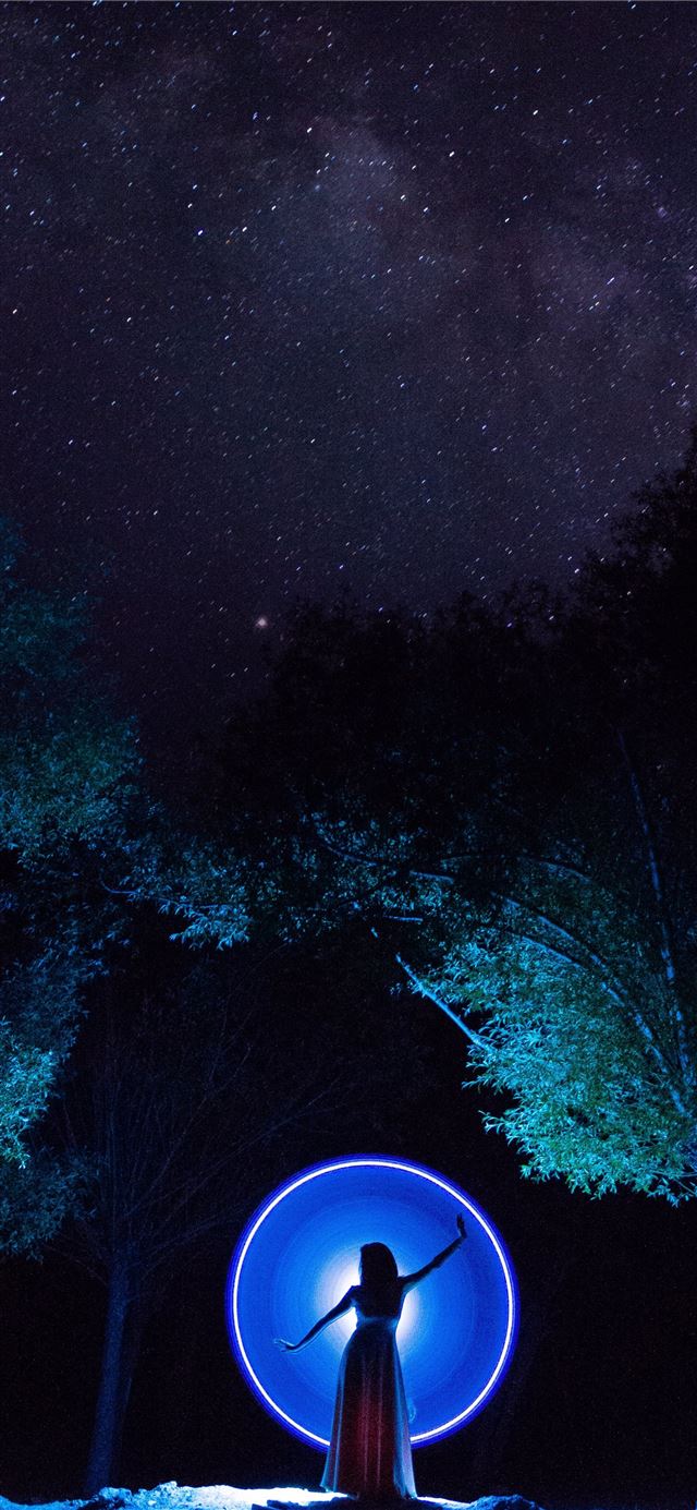1125x2436 woman in dress standing in between trees -  iPhone 11 Wallpaper