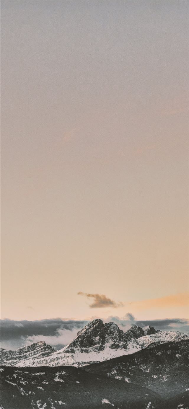 1284x2778 rock formation coated with snow under orange sky -  iPhone 11 Wallpaper