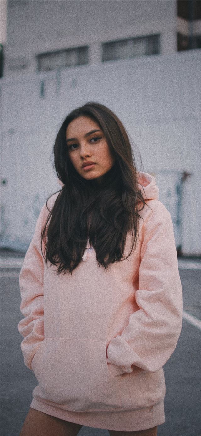 1284x2778 woman wearing pink pullover hoodie standing near w... -  iPhone 11 Wallpaper