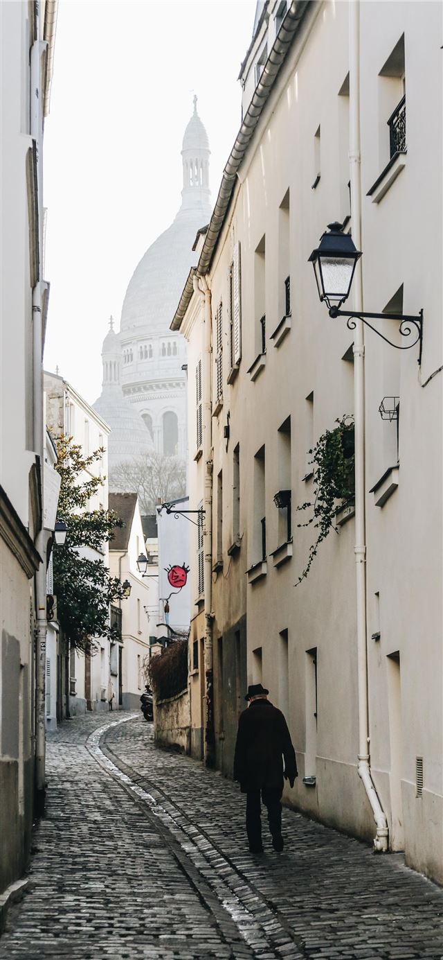 1284x2778 man walking near concrete building -  iPhone 11 Wallpaper
