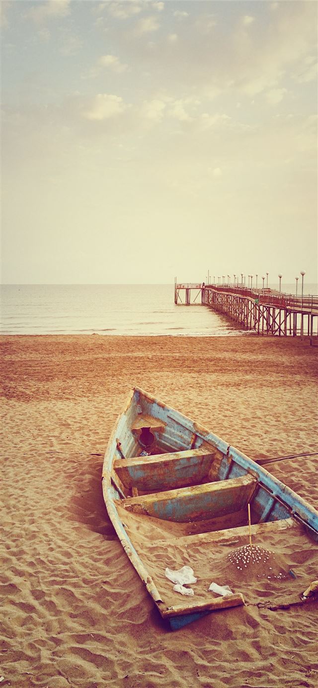 1284x2778 blue canoe boat on brown sand near brown wooden do... -  iPhone 11 Wallpaper