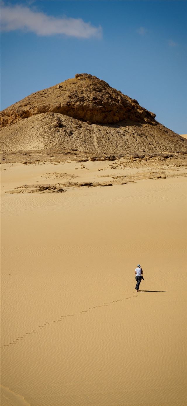 1125x2436 man in white shirt walking on brown sand during da... -  iPhone 11 Wallpaper