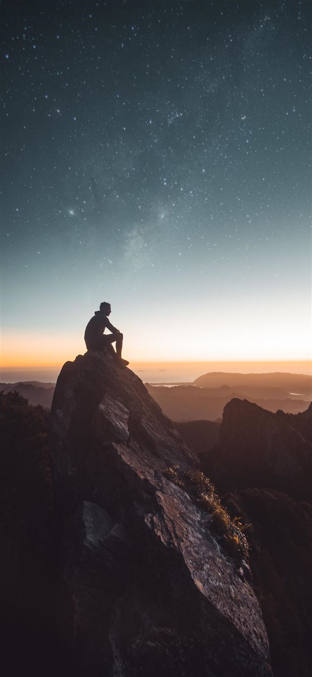1125x2436 silhouette of person sitting on rock formation dur... -  iPhone 11 Wallpaper