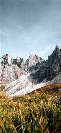 grass field near rock formation wallpaper