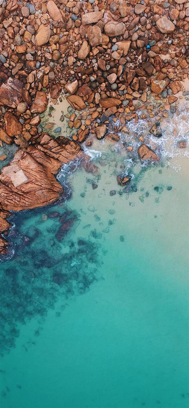 1125x2436 clear blue sea and rocks - hong kong iPhone 11 Wallpaper