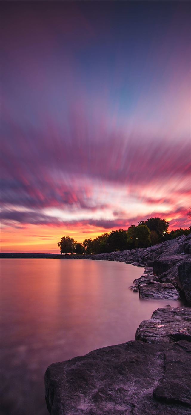 1125x2436 body of water and gray rock formation - sunset iPhone 11 Wallpaper