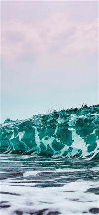 person surfing on sea waves during daytime iPhone 11 wallpaper