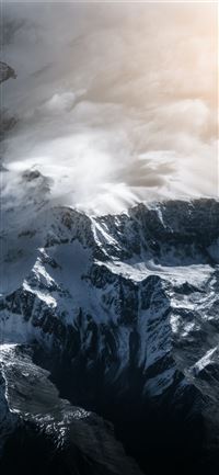 snow covered mountain under cloudy sky during dayt... iPhone 11 wallpaper