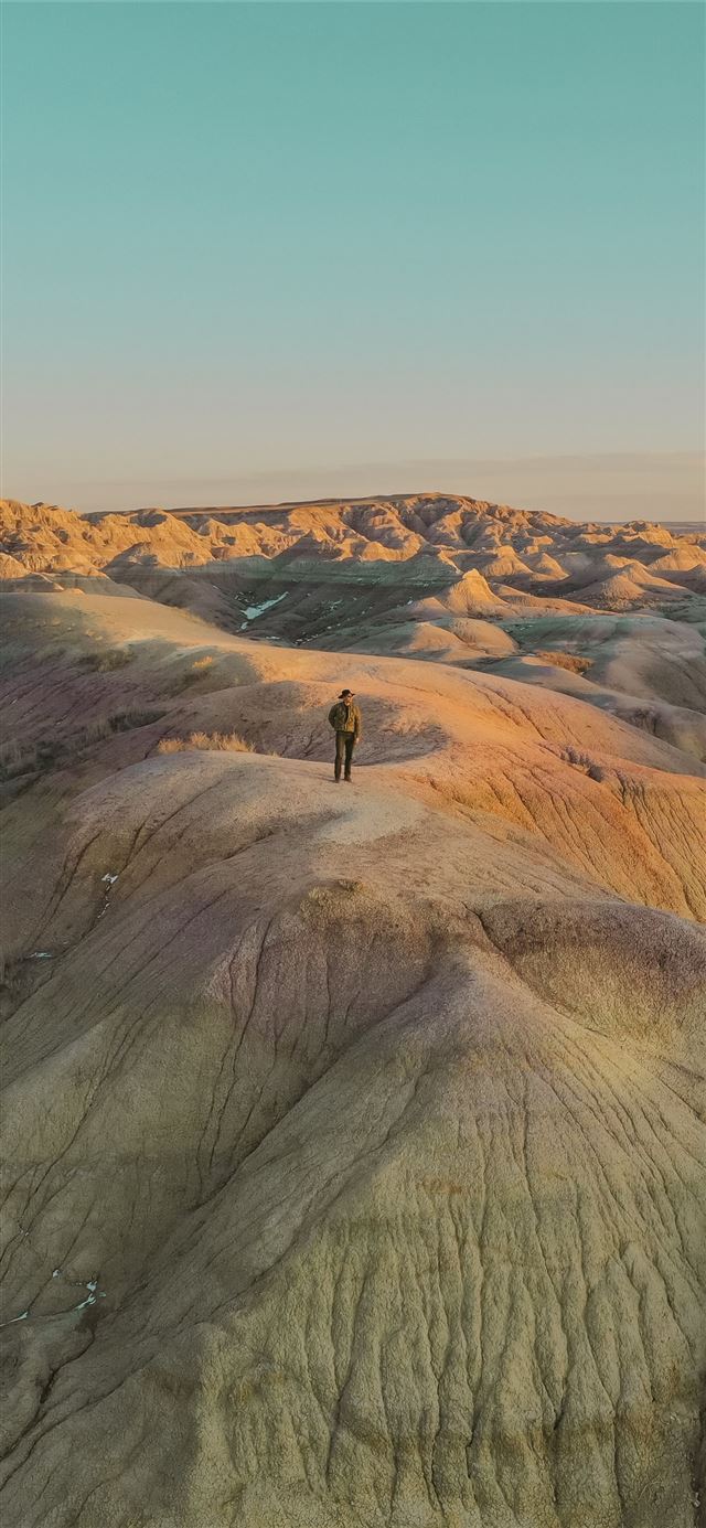 1125x2436 person standing on brown rock formation during day... -  iPhone 11 Wallpaper