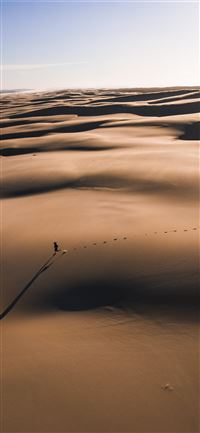 person walking on the desert photography iPhone 11 wallpaper