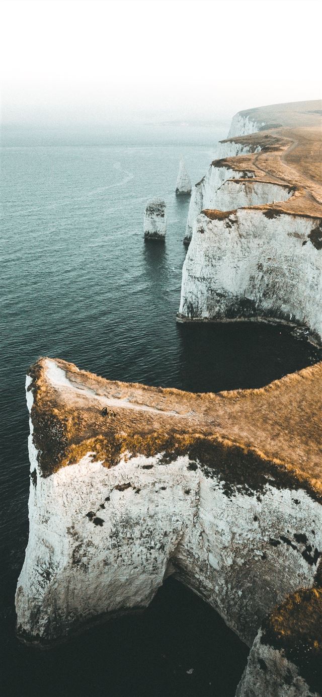 1125x2436 aerial view photography of mountain cliff near bod... - travel iPhone 11 Wallpaper
