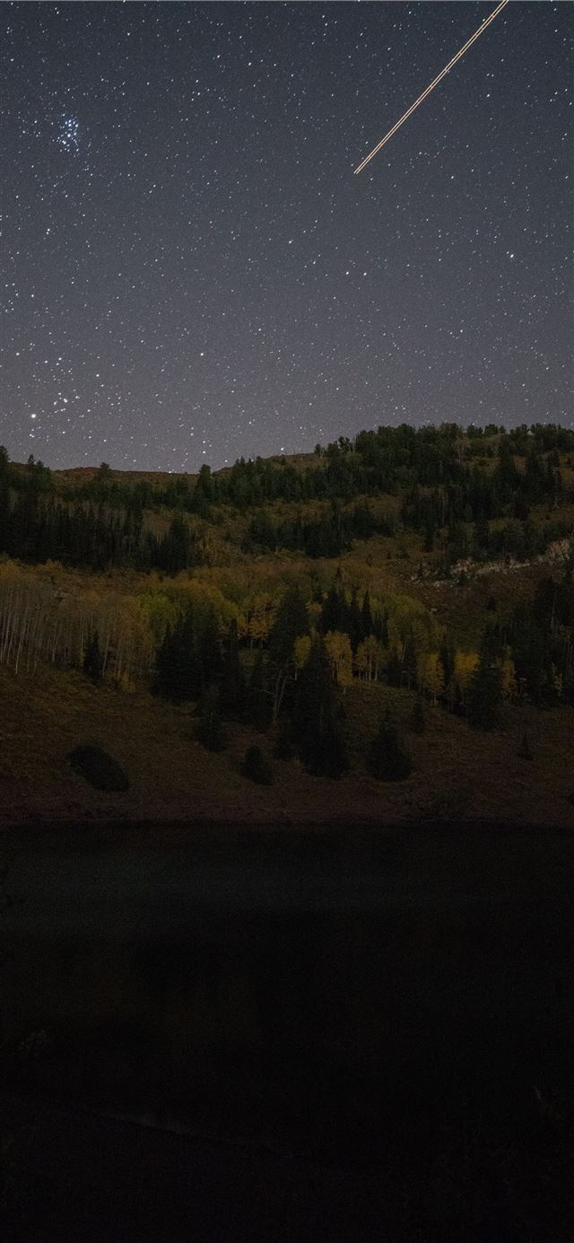 1125x2436 shooting star over green mountain during nighttime - space iPhone 11 Wallpaper
