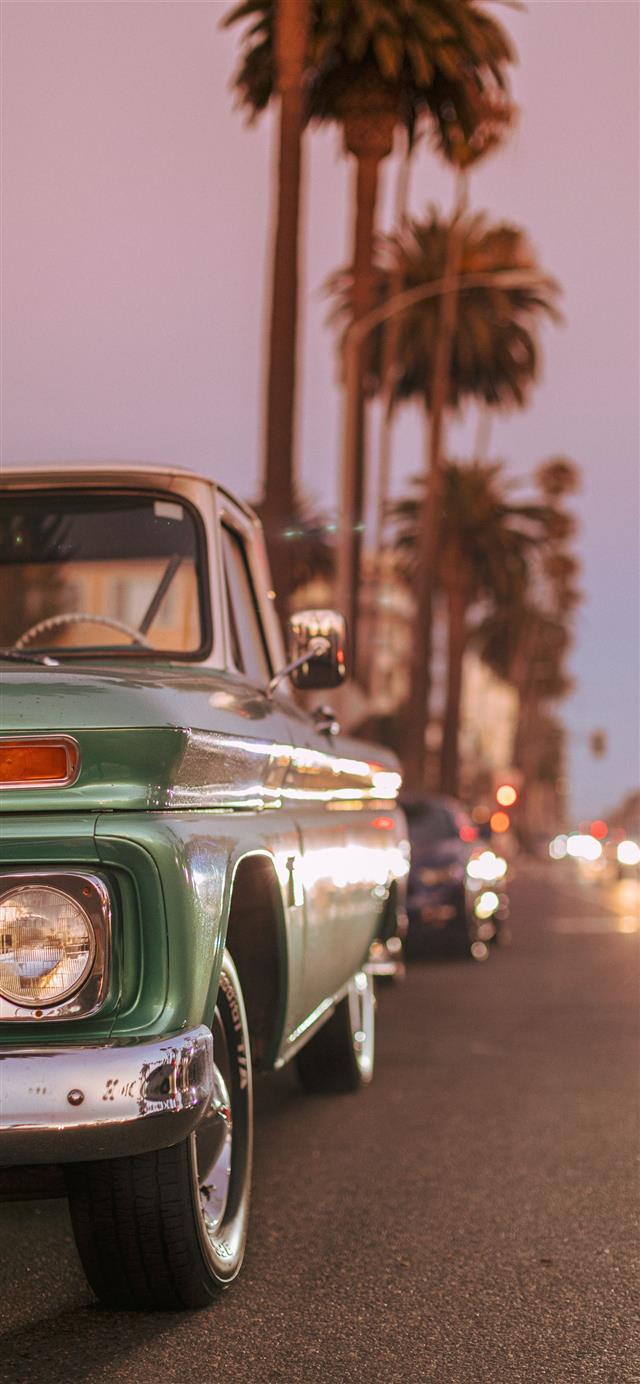 Vintage car parked on Ocean Blvd during sunset  iPhone 12 wallpaper 
