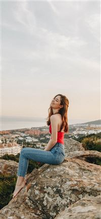woman sitting on rock during daytime wallpaper