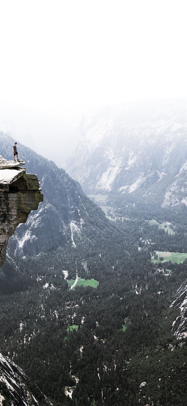 man on mountain cliff iPhone 12 wallpaper 