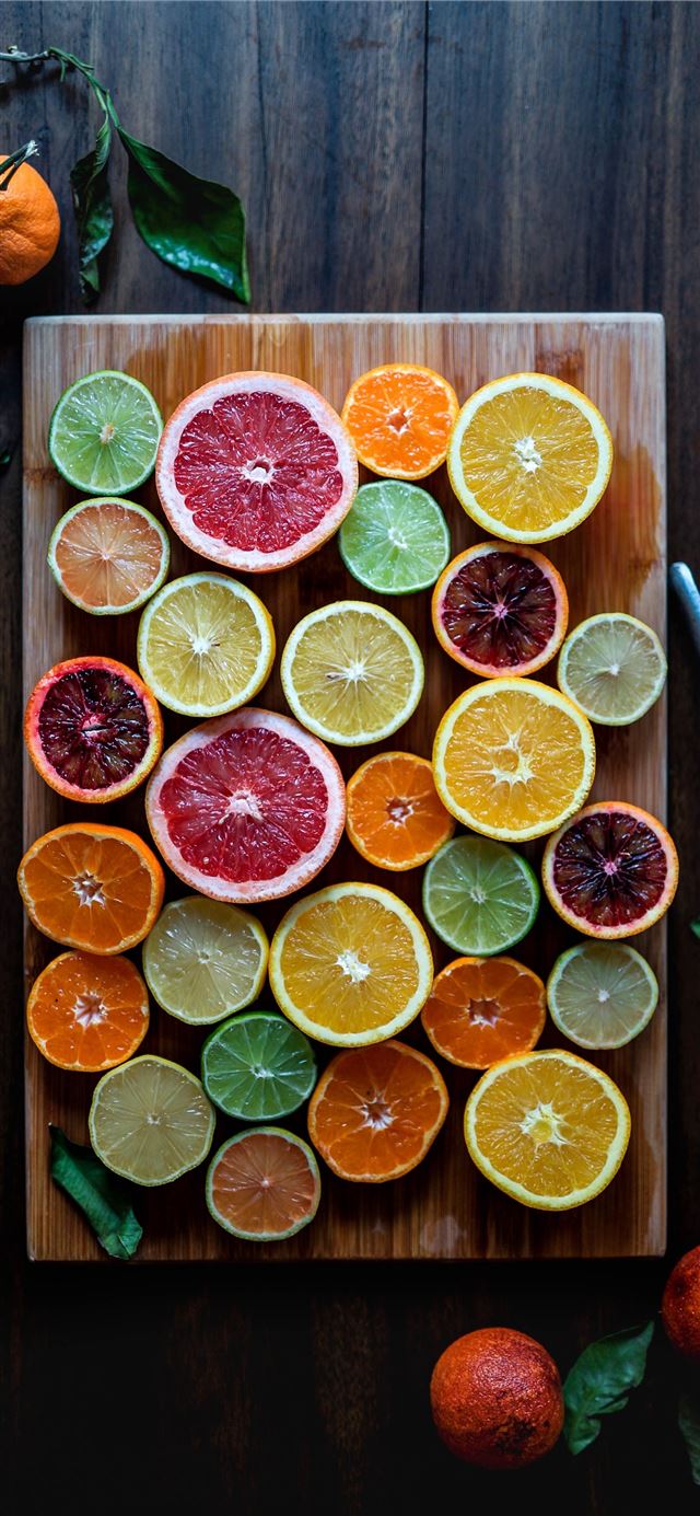 assorted sliced citrus fruits on brown wooden chop... iPhone 12 wallpaper 