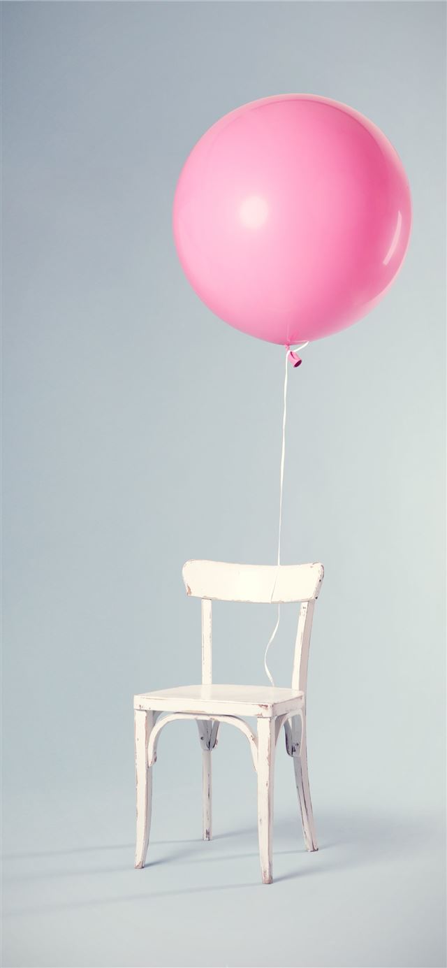 pink balloon tied on white wooden chair iPhone 12 wallpaper 