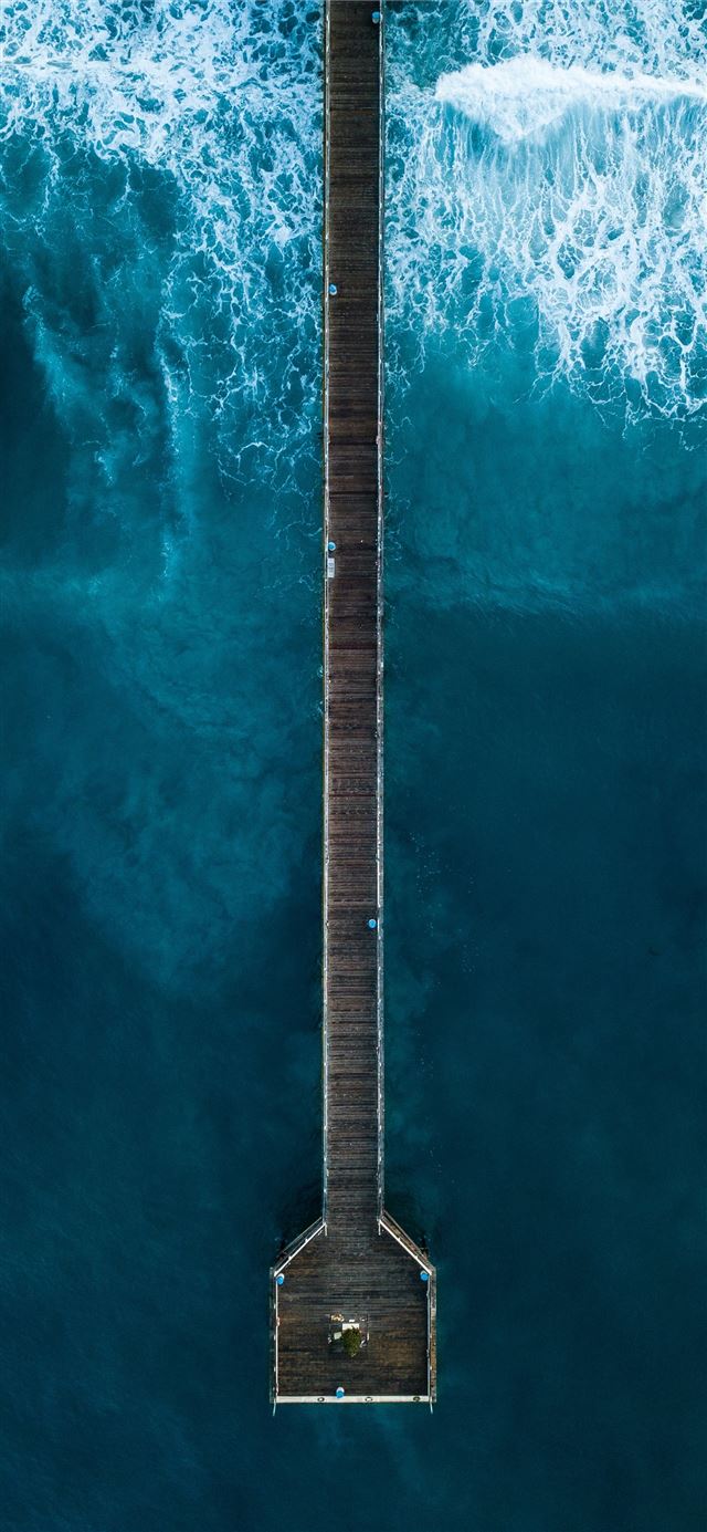 aerial photography of person standing on dock besi... iPhone 12 wallpaper 
