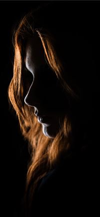 woman's face on black background wallpaper