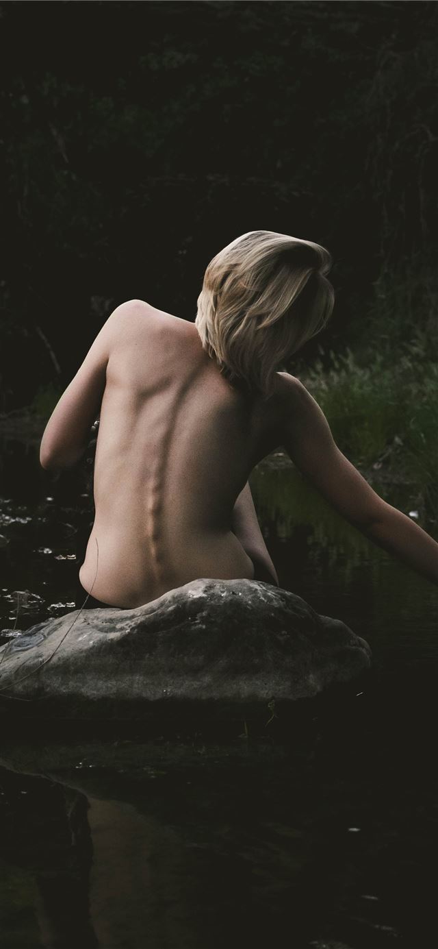half naked woman sitting on rock iPhone 12 wallpaper 