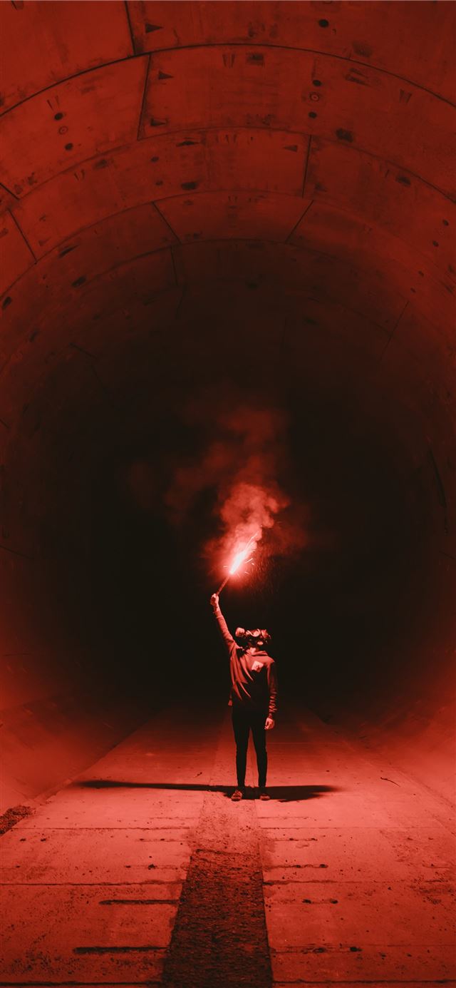 man wearing gas mask holding torch inside tunnel iPhone 12 wallpaper 