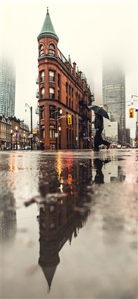 man using umbrella crossing the street during dayt... wallpaper