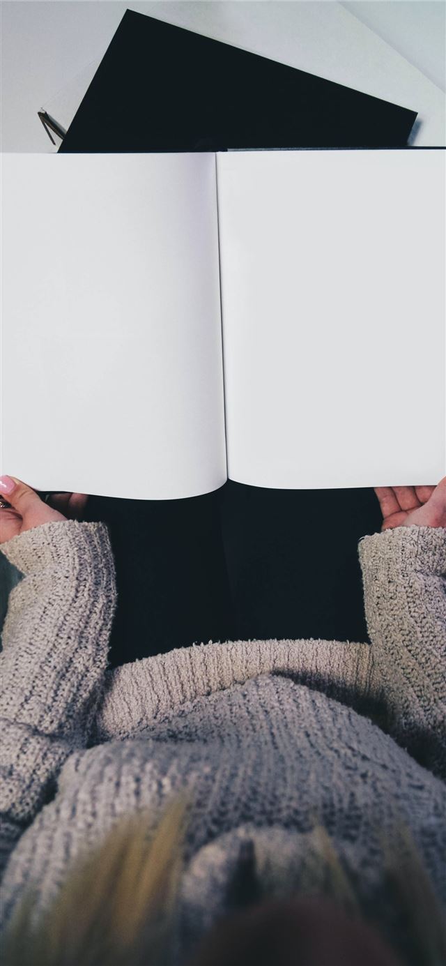 woman wearing sweater opening blank book iPhone 12 wallpaper 