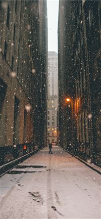 person standing between brown high rise buildings ... wallpaper