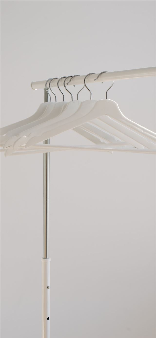 white clothes hangers hanging on rack iPhone 12 wallpaper 