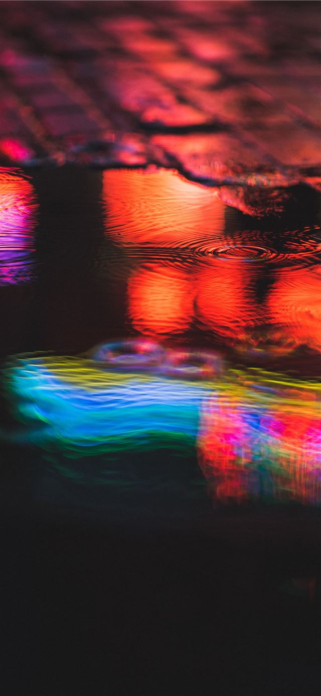 red and blue light reflection on water iPhone 12 wallpaper 