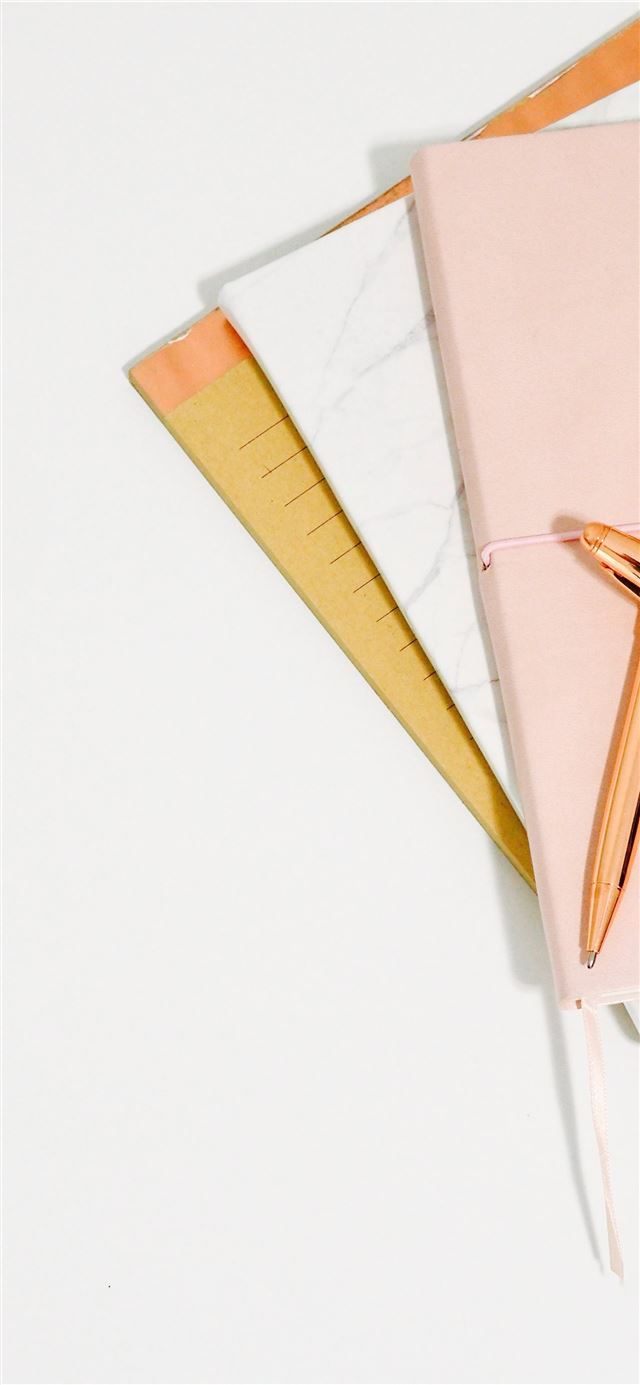 ballpoint pens on pink notebook iPhone 12 wallpaper 
